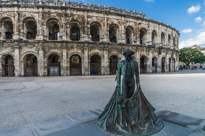 Roman Arena in Arles and bullfighter sculpture