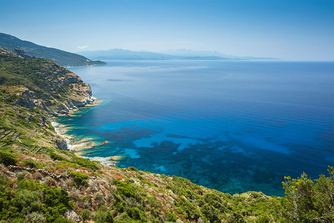 The coast of Cap Corse near Minerviu in Corsica with Desert des Agriates in the background