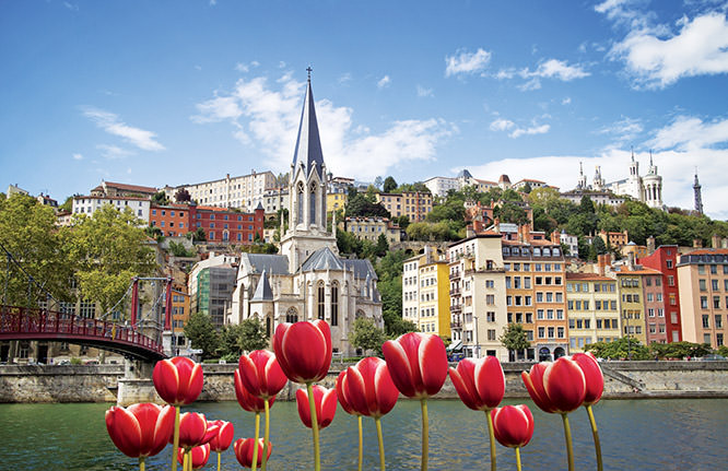Cityscape of colorful old Lyon with red tulips