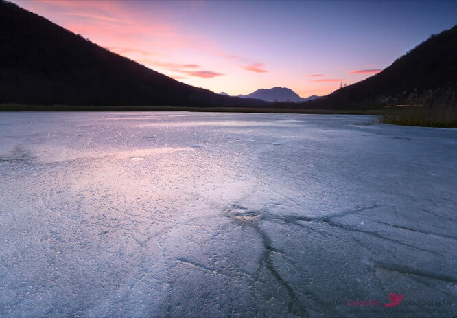 Frozen Varese lake in winter at sunset