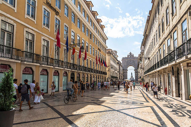 Walking in central street with view on big arch
