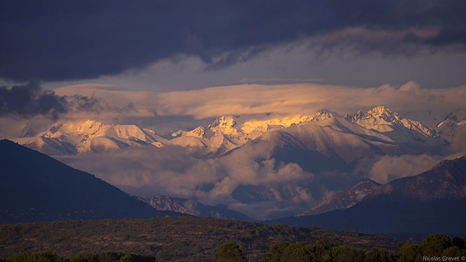 The sun sets on the snowy peaks of the southern Alps as seen from Antibes