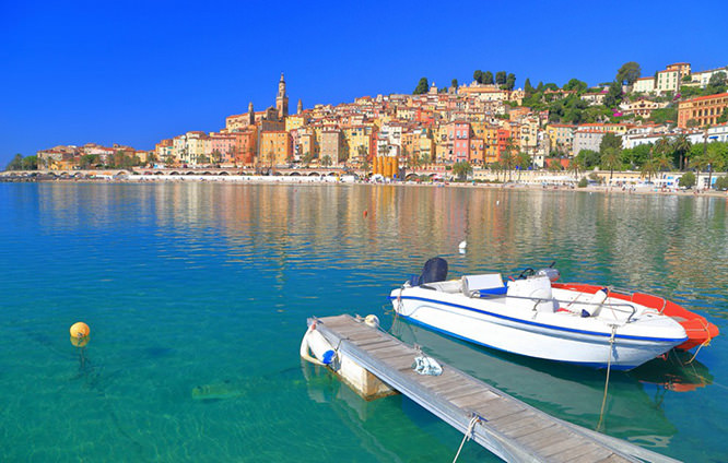 Leisure boats near the shore and the old town of Menton in the background French Riviera