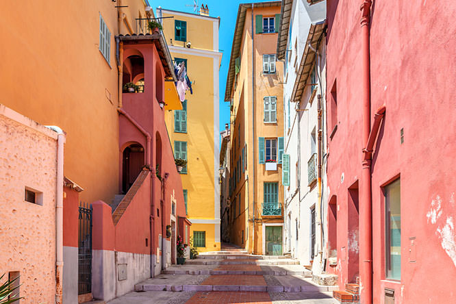 Narrow street among old colorful houses in Menton